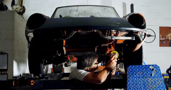 Male mechanic using grinder machine 