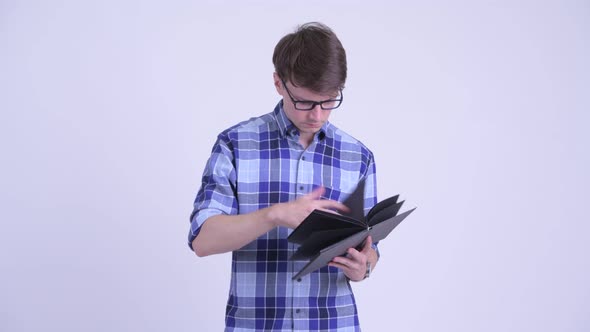 Happy Young Handsome Hipster Man Reading Book with Eyeglasses