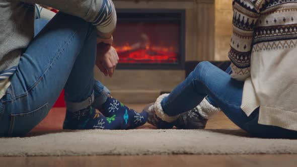 Young Couple with Warm Socks in Front of Fireplace