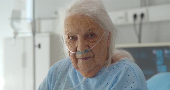 Senior Woman Sitting on Hospital Bed and Looking at Camera