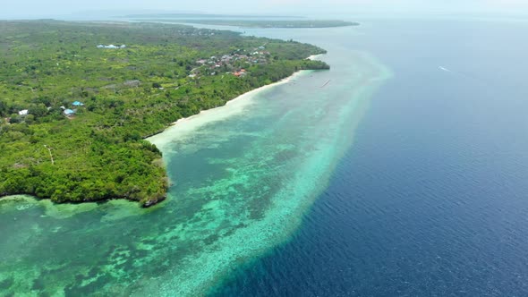 Aerial: Flying over tropical beach turquoise water coral reef , Tomia island Wak