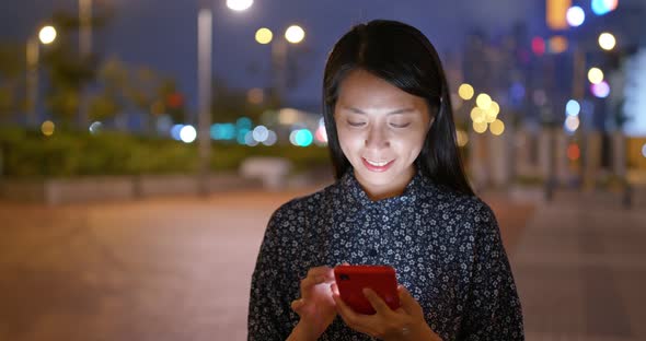 Young woman use of mobile phone in city at night