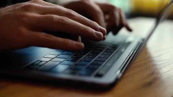 Close-up of Men's Hands Starting To Type on Dark Laptop Keyboard