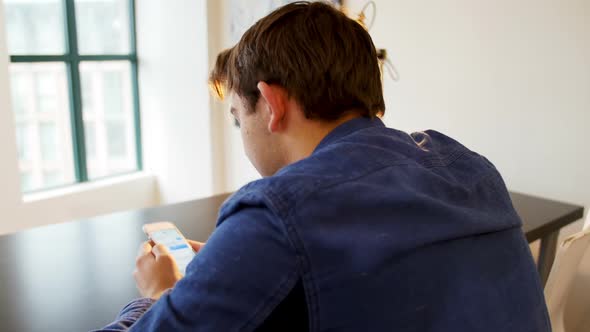 Man using mobile phone with black coffee on table