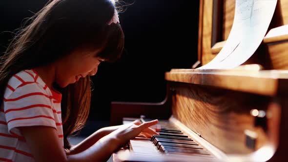 Schoolgirl learning piano in music class 4k