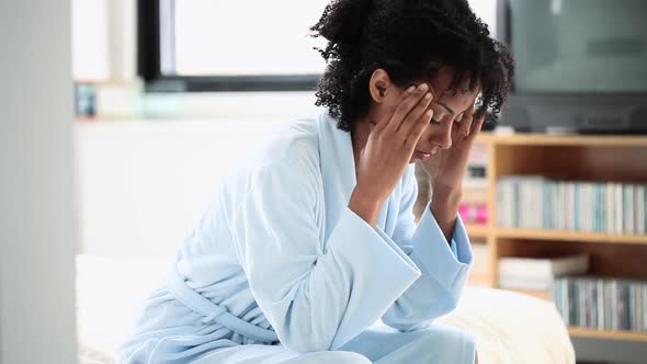 Woman in bathrobe looking anxious and depressed