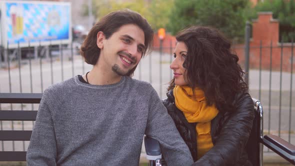 couple flirting - young man talking to his girlfriend with disability at park