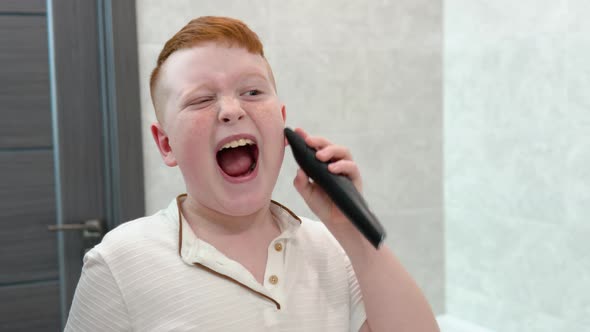 Little Boy is Shaving His Face with Electric Razor in the Bathroom