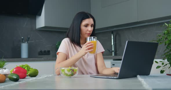 Woman which Working at Home on Computer During Snack with Vegetable Salad