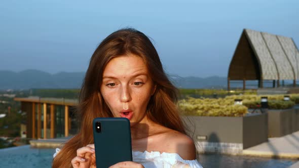 Portrait of Surprised and Happy Woman Enjoy Success or Win on Mobile Phone