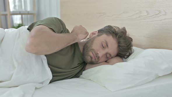 Tired Young Man Having Neck Pain While Sleeping in Bed