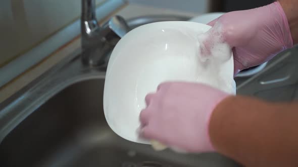 Close Up Man Hands Washing Dishes in the Kitchen Sink