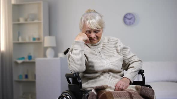 Depressed Old Woman in Wheelchair Thinking About Health Problems at Hospital