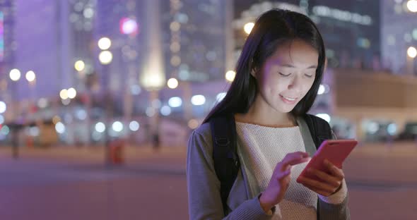 Woman use of mobile phone in city at night