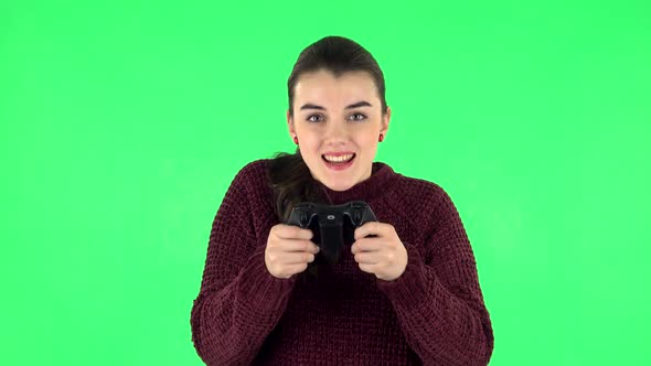 Girl Playing a Video Game Using a Wireless Controller with Joy and Rejoicing in Victory