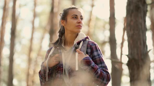 Tourist Woman with Backpack in Forest