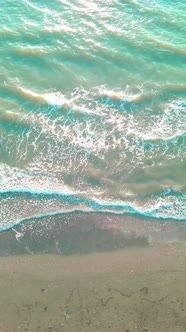 Drone view of the beautiful waves on the sandy beach,