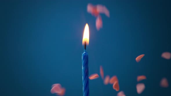 Deep Blue Candle on Deep Blue Background and Sugar Hearts Falling on Background