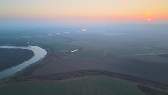 Aerial View of Wide River Flowing Quietly in Rural Countryside in Autumn Evening