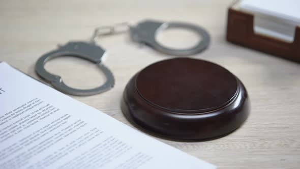 Handcuffs on Table, Gavel Striking on Sound Block, Crime Punishment, Law Order