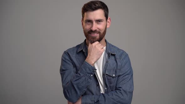 Portrait of thoughtful brunette man with beard pondering idea, confused not sure about solution