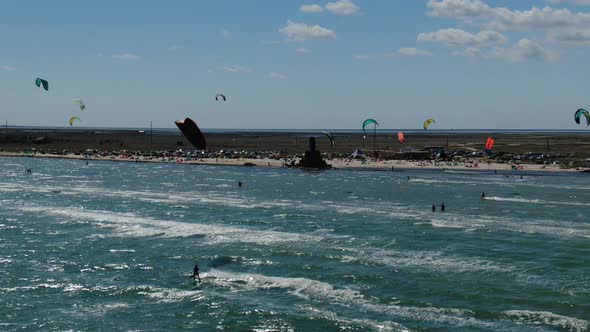 Kites of Different Colors Are Flying in the Sky While People Are Kitesurfing