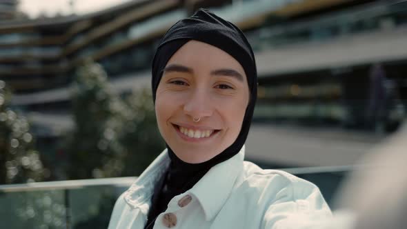 Smiling Woman in Hijab Recording Video on Mobile Near Shopiing Mall