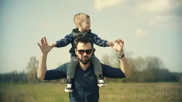 Little Kid Having Fun. Boy Son Sitting On Father Neck. Happy Family Father Day And Child Son Leisure