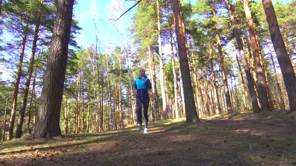 Girl on a Morning Run in a Sunny Forest