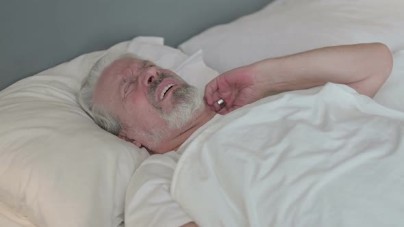 Exhausted Old Man with Neck Pain in Bed