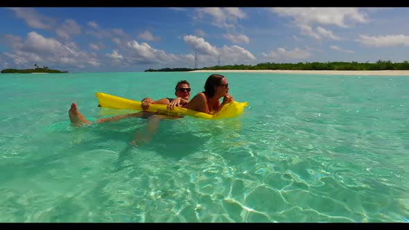 Two people tan on beautiful tourist beach time by blue sea with bright sandy background of the Maldi