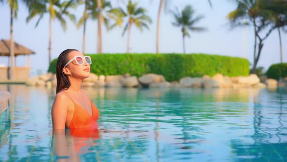 Young asian woman enjoy around outdoor swimming pool for leisure