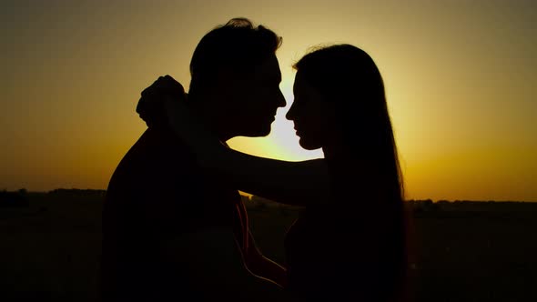 Silhouette of Couple in Love Embrace at Sunset