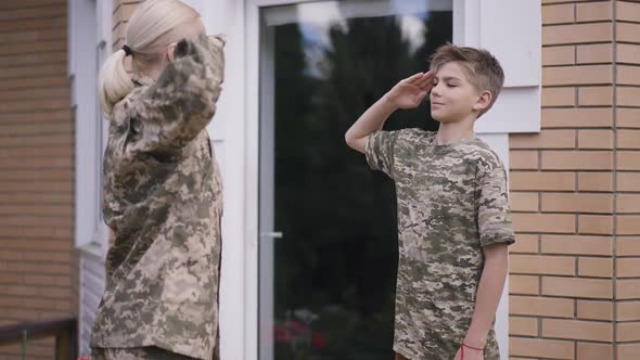 Teenage Boy Learning Saluting in Slow Motion As Military Woman Adjusting Posture and Hand