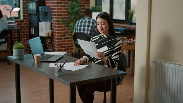 Portrait of Asian HR Recruiter Analyzing Cv Resume of Candidate