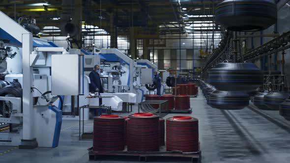 Workers at Tire Plant Manufacturing New Rubber Product Controlling Production