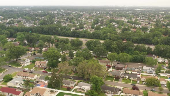 An aerial view over a suburban neighborhood on a cloudy day. The camera tilted down, dolly in over t