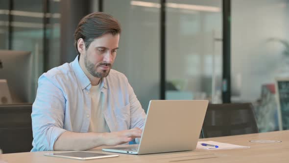 Mature Adult Man with Laptop Shaking Head As Yes Sign