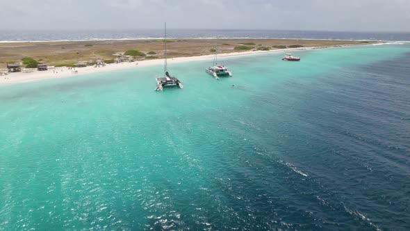 Aerial fast orbit over the sandy beach of the Klein Curacao island