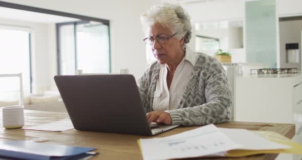 Thoughtful african american senior woman using laptop at home