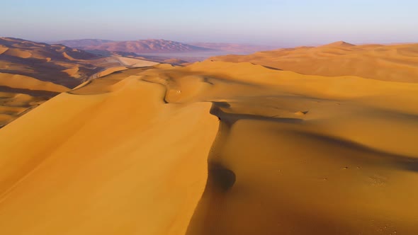 Aerial view of a man sitting on the edge of dunes, U.A.E.