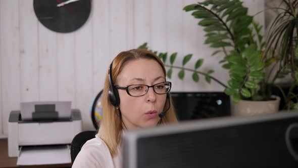 Smiling Woman Working As Customer Support Operator with Headset in a Call Center