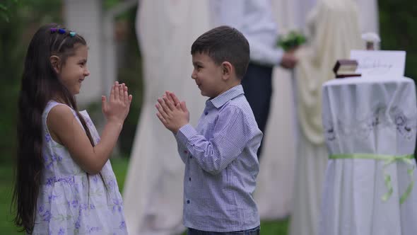 Happy Cheerful Middle Eastern Children Clapping Smiling Looking at Camera with Unrecognizable Couple