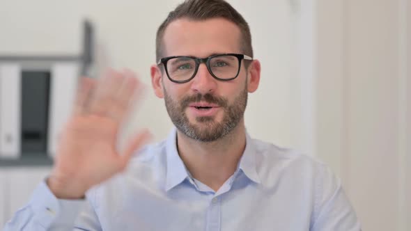 Portrait of Middle Aged Man Waving at the Camera