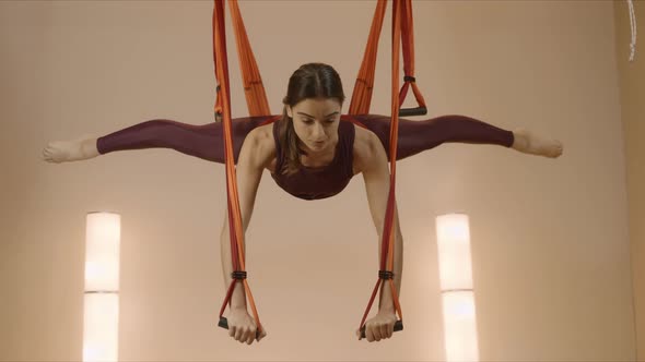 Woman Doing Split in Hammock at Class. Sportswoman Practicing Antigravity Yoga