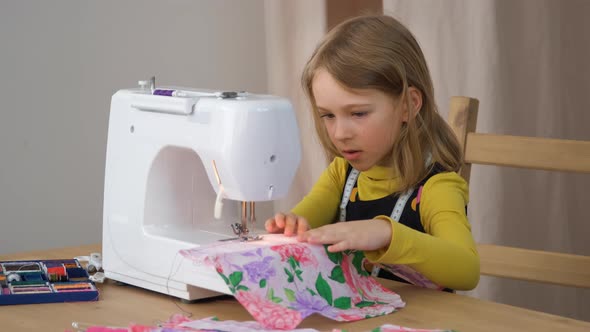 Little Girl Sewing Clothes on Sewing Machine
