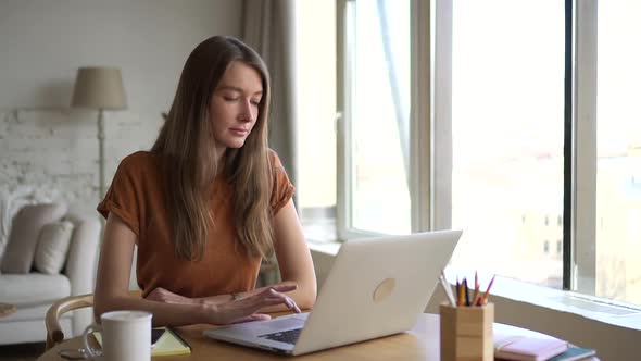 Woman Sit at Home and Think of Idea While Working at Laptop