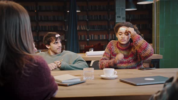 Mixed Race Group of Friends Playing Guessing Game at Library