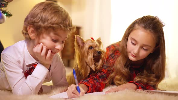 Beautiful Little Sister Helping Cute Brother Writing Letter to Santa on New Year's Eve