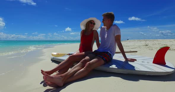 Romantic couple on romantic honeymoon live the dream on beach on clean white sand 